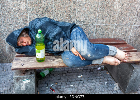 Ein betrunkener, schlafender Obdachloser auf der Straße, auf einer Bank liegend, ein Mensch auf dem Wenzelsplatz, Prag, Tschechische Republik allein ein älterer Mann obdachloser älterer Mann Stockfoto