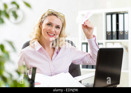Geschäftsfrau werfen Papierflieger im Büro Stockfoto