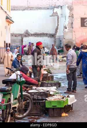 Männer verkaufen Fisch und Gemüse in am frühen Morgen auf einem kleinen Markt in Marrakesch, Marokko Stockfoto
