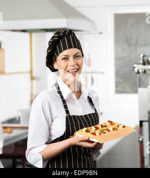 Happy Chef Holding Tablett mit gefüllte Teigwaren Blatt Stockfoto