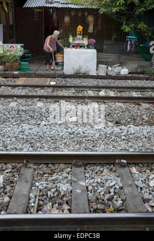 Alte Dame lebt neben der Bahngleises verfolgt in der Innenstadt von Bangkok Stockfoto