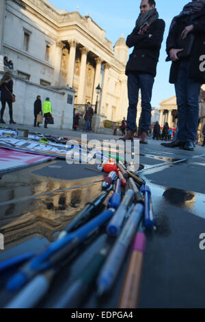 Trafalgar Square, London, UK. 8. Januar 2015. Mitglieder von den öffentlichen Blick auf die Je Suis Charlie Memorial, Karten und Bilder sind umgeben von einem Ring von Stiften auf dem Trafalgar Square. Stockfoto