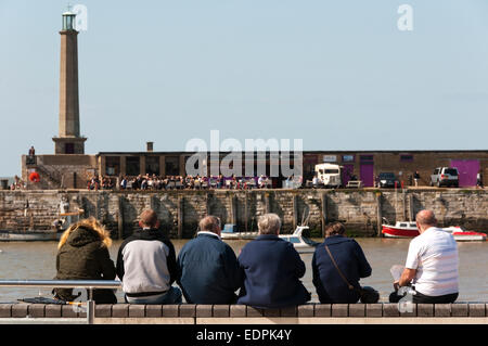 Menschen sitzen an Wand in Margate direkt am Meer. Stockfoto