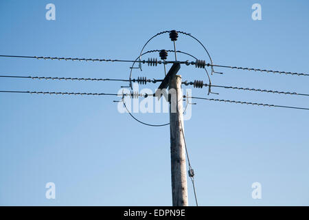 Nahaufnahme von Stromkabeln und Telegrafenmast gegen blauen Himmel, UK Stockfoto