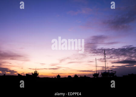 Angeln / Segeln Boote auf dem Festland bei Sonnenaufgang im Hafen von Lindisfarne, Holy Island, Northumberland, England. Silhouette Stockfoto