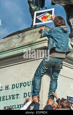 Genf, Schweiz. 8. Januar 2015. Ein Journalist, klettert auf eine Statue des Schweizer Held General Dufour ein Plakat während eine Mahnwache in Genfs Place de Neuve zur Solidarität mit den Opfern des Angriffs gegen Charlie Hebdo in Paris Credit setzen: Alistair Scott/Alamy Live News Stockfoto