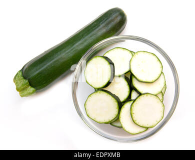 Zucchinischeiben auf Schüssel auf weißem Hintergrund von oben gesehen Stockfoto