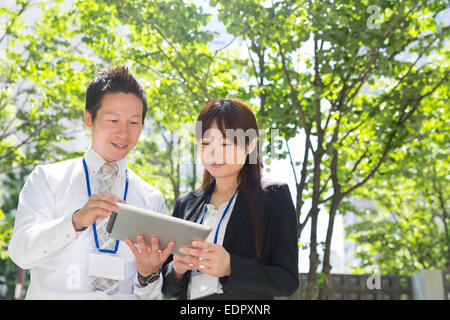 Geschäftsleute, die am Tablet-Computer Stockfoto