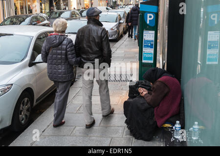 Frau Betteln auf Rue St Honore, eine modische, hochwertige Einkaufsstraße im Zentrum, Zentrum von Paris. Stockfoto