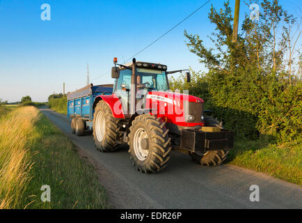 Traktor fahren entlang Landstraße in Suffolk, UK Stockfoto