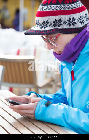 Frau im Skigebiet mit Smartphone. Stockfoto