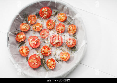 Auflaufform Tomaten gewürzt mit Knoblauch, Gewürze und Zucker für die Herstellung von Tomaten confit Stockfoto