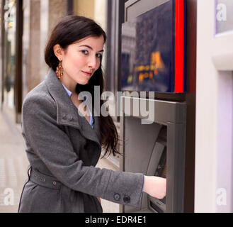 junge Frau bei der Geldautomat Stockfoto