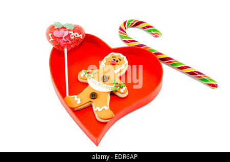 Lebkuchen eine Zuckerstange und einen Lutscher in ein Herz Feld isoliert auf weißem Hintergrund geformt Stockfoto