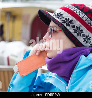 Frau im Skigebiet mit Smartphone. Stockfoto