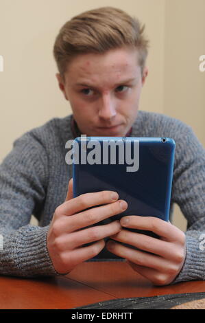 Teenage Boy Verwendung An Apple Ipad Tablet Stockfoto