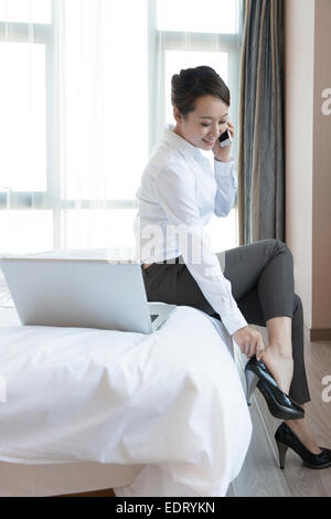 Junge Frau, die Schuhe, mit mobilen aufsetzen Stockfoto