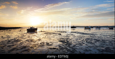 Boote bei Sonnenaufgang im Hafen von Lindisfarne, Holy Island, Northumberland, England. Silhouette Stockfoto