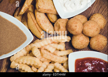 Snack-Kartoffel-Teller mit Dips auf Holzbrett Stockfoto