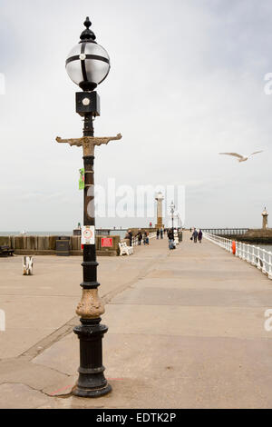 Großbritannien, England, Yorkshire, Whitby, Besucher zu Fuß entlang der West Pier zum Leuchtturm Stockfoto