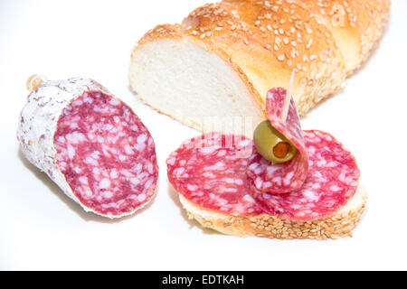 Brot mit Scheiben Salami auf weißem Hintergrund Stockfoto