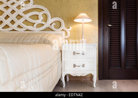 Weiße Vintage-Stil Nachttisch mit Lampe in einem Schlafzimmer Stockfoto