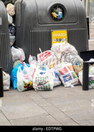 MADRID, Spanien - 27. Dezember 2014: Behälter für das recycling auf der Straße, umgeben von Müll. Stockfoto