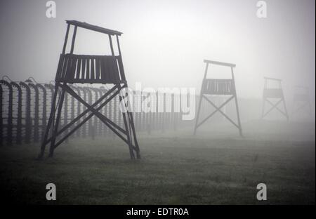 Oswiecim, Polen. 5. Oktober 2014. Stehen Sie der Stacheldraht kabelgebundene Zaun und ein-Mann-Wachtürme des KZ Auschwitz-Birkenau, auch bekannt als Auschwitz II überdachte im Nebel in Oswiecim, Polen, 5. Oktober 2014. Rund 8.000 SS-Offiziere bewacht das Lager. Befreiung des Lagers wurde durch sowjetische Truppen am 27. Januar 1945 und wurde 1947 in eine Gedenkstätte und ein Museum umgebaut. Das Camp ist seit 2007 aufgeführten Weltkulturerbe der UNESCO, offiziell als "Auschwitz-Birkenau - deutschen nationalen sozialistischen Konzentrations- und Vernichtungslager" betitelt. Foto: Frank Schumann/Dpa - NO-Draht-SERVICE-/ Dpa/Alamy Live News Stockfoto