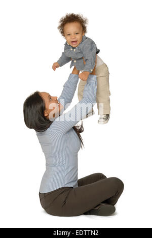 Attraktive junge Mutter sitzt und hält ihre lächelnden einjährigen Sohn. Stockfoto