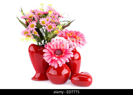 Blumen in Vasen und Glas Herz isoliert auf weißem Hintergrund. Stockfoto