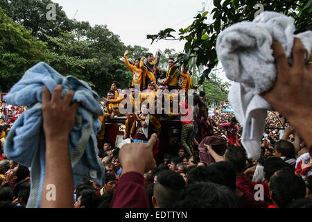 Anhänger versuchen, Handtücher in den Black Nazarene Wagen werfen. Etwa 2 Millionen Anhänger nahmen an der jährlichen Prozession des schwarzen Nazareners, dauern in der Regel 24 Stunden. Ein Anhänger ist tot, während des frühen Teils der Prozession durch Herzinfarkt, berichtet worden. © J Gerard Seguia/Pacific Press/Alamy Live-Nachrichten Stockfoto