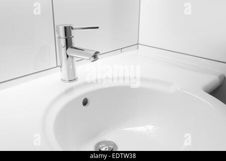 Wasserhahn und weiß Waschbecken im Badezimmer Stockfoto