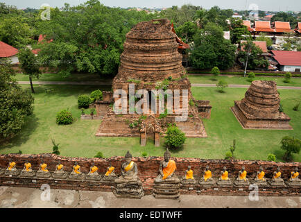 THAILAND - Blick von der wichtigsten Chedi im Wat Chai Mongko in Ayutthaya über die Linie der Buddhas, die die Struktur umgeben. Stockfoto