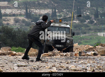 Nablus. 9. Januar 2015. Ein palästinensischer Demonstrant wirft Steinen auf israelische Soldaten bei einem Protest gegen den Ausbau der jüdischen Siedlungen im Kufr Qadoom Dorf in der Nähe von West Bank Stadt von Nablus, am 9. Januar 2015. © Nidal Eshtayeh/Xinhua/Alamy Live-Nachrichten Stockfoto