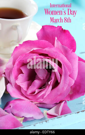 Glücklich International Womens Day Gruß mit rosa Rosen und am Nachmittag Tee Tablett auf rosa Hintergrund mit Beispieltext. Stockfoto