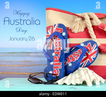 Australischen Strand-Szene mit Aussie Sandalen, Strandtasche, Sonnenbrille und Schale mit Blick auf Meer Stockfoto
