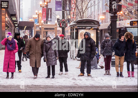 Chicago, USA, 8. Januar 2015.  Der Windy City weiterhin die Druckwelle der arktischen Temperaturen ertragen die unter-20 C und mehr mit dem Windchill erreicht.  Im Bild: Shopper auf der State Street ertragen einen Schneesturm.  Bildnachweis: Stephen Chung/Alamy Live-Nachrichten Stockfoto