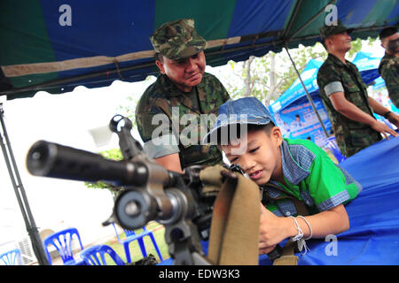 Bangkok, Thailand. 10. Januar 2015. Ein Kind berührt eine Maschinengewehr am Kindertag in der Royal Thai Navy Academy in Süd-Bangkok, Thailand, 10. Januar 2015. Die Thai nationaler Kindertag wird an jedem zweiten Samstag im Januar gefeiert. Bildnachweis: Rachen Sageamsak/Xinhua/Alamy Live-Nachrichten Stockfoto