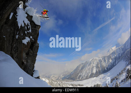 Ein Skifahrer springt von einer Klippe abseits der Piste in der französischen Skiort Courchevel. Stockfoto