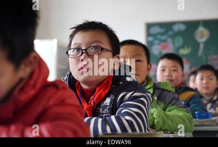 (150110)--TONGGU Grafschaft, 10. Januar 2015 (Xinhua)--Mo Shuangyi besucht eine Schulstunde in Tonggu Grafschaft von Yichun, Osten Chinas Jiangxi Provinz, 9. Januar 2015. Nachdem sein Vater an Leukämie im Oktober 2014, Shuangyi, erkrankte 10-jährige Schüler in Tonggu Grafschaft, beschlossen, wiederverwertbare Abfälle zu sammeln und sie für Geld zu verkaufen, um seinen Vater zu retten, der Verzicht auf Behandlung wegen der hohen medizinischen Kosten gedacht. Seine kindlichen Taten erregte umfangreiche Aufmerksamkeit, wenn Bilder von ihm sammeln Abfälle über das Internet zu verbreiten. Shuangyi der Familie erhielt öffentliche Spenden und eine Reihe von s Stockfoto