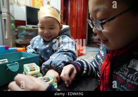 (150110)--TONGGU Grafschaft, 10. Januar 2015 (Xinhua)--Mo Shuangyi (R) spielt Mahjong Blöcke mit seinem jüngeren Bruder in ihrem Haus in Tonggu Grafschaft von Yichun, Osten Chinas Jiangxi Provinz, 9. Januar 2015. Nachdem sein Vater an Leukämie im Oktober 2014, Shuangyi, erkrankte 10-jährige Schüler in Tonggu Grafschaft, beschlossen, wiederverwertbare Abfälle zu sammeln und sie für Geld zu verkaufen, um seinen Vater zu retten, der Verzicht auf Behandlung wegen der hohen medizinischen Kosten gedacht. Seine kindlichen Taten erregte umfangreiche Aufmerksamkeit, wenn Bilder von ihm sammeln Abfälle über das Internet zu verbreiten. Shuangyi der Familie rec Stockfoto