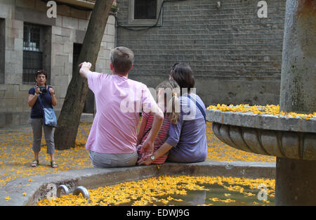 Familie mit ihrem Foto mit Vater geben Anweisungen, Brunnen im Plaça Sant Felip Neri, Barcelona. Stockfoto