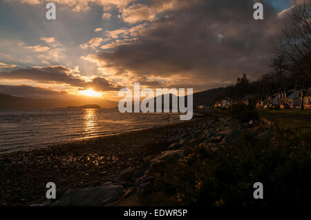 Die Sonne einstellen über Loch Carron auf einen Winter-Abend und reflektiert die Gebäude im Dorf. Stockfoto