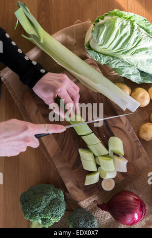 Ein Womans Hände schneiden Gemüse für ein Rezept. Stockfoto