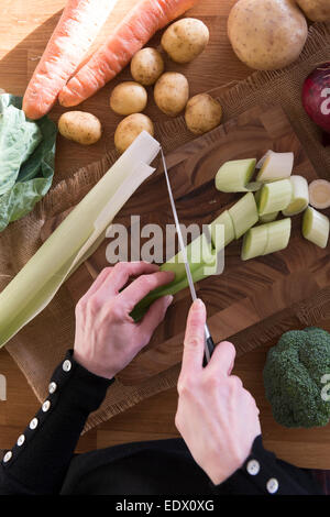 Ein Womans Hände schneiden Gemüse für ein Rezept. Stockfoto