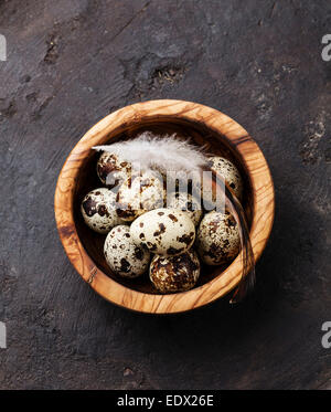 Oliven Holz Schüssel mit frischen Wachteln Eiern auf dunklem Hintergrund Stockfoto