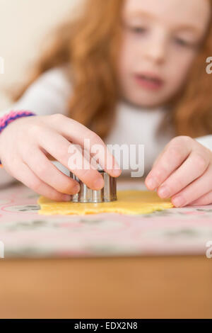 Kleine Mädchen machen Mine Torten Marzipan abgedeckt. Stockfoto