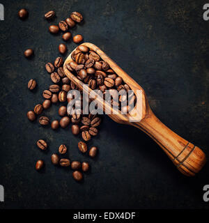 Kaffeebohnen und eine alte hölzerne Schaufel auf dunklem Hintergrund Stockfoto