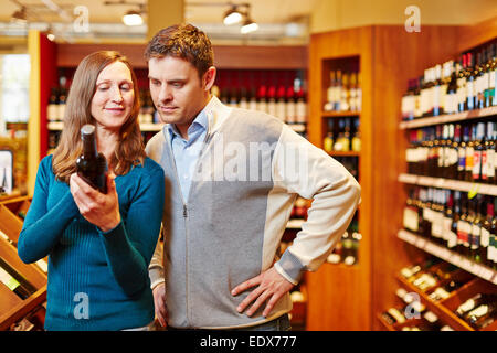 Paar für Flasche Rotwein in einem Getränkemarkt einkaufen Stockfoto