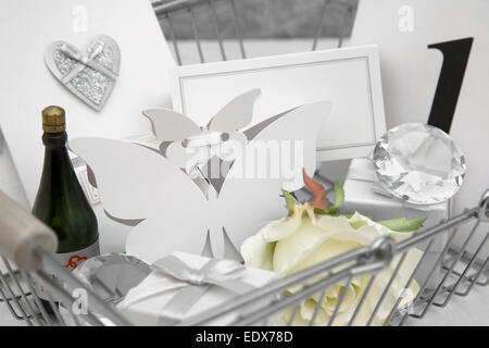 Hochzeit Gefälligkeiten in einem Warenkorb auf eine weiße Tischdecke mit Bändern, Schleifen, Herzen Konfetti und kleinen Diamanten Tischdeko Stockfoto